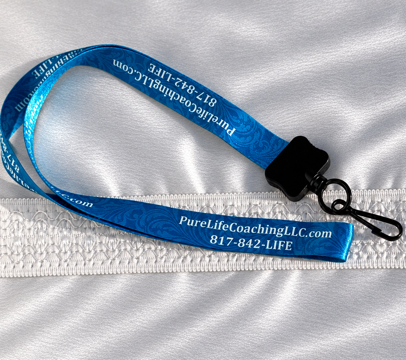 Blue Pure Life Coaching LLC branded lanyard with a black key ring and clip